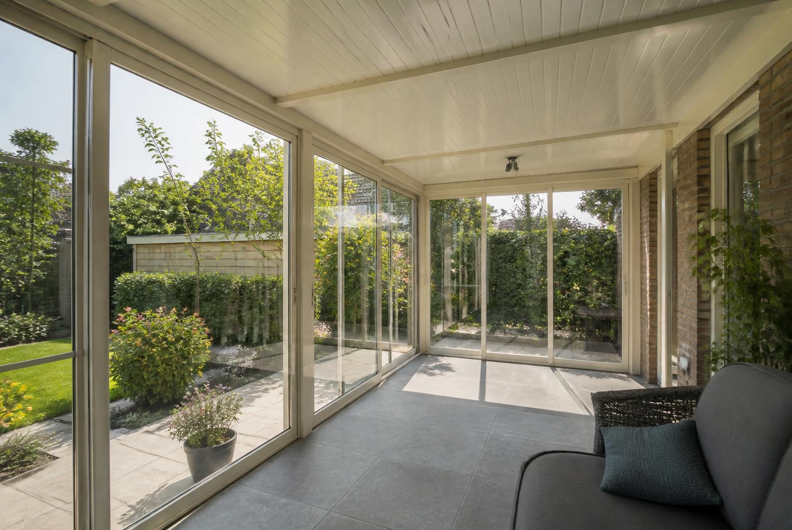 Veranda met glazen schuifwanden in de tuin